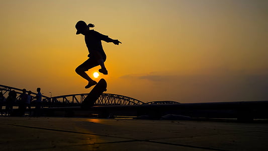 silhouette photo of person skating during golden hour