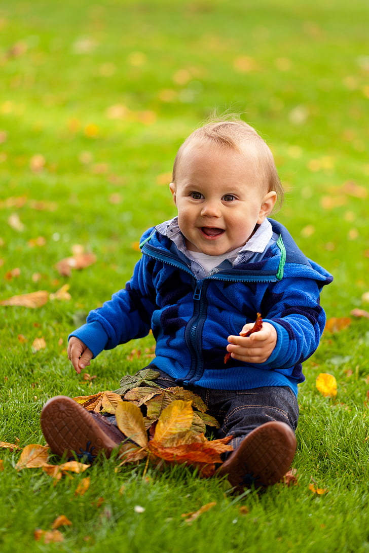 toddler wearing blue zip-up jacket smiling