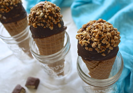 three chocolate ice creams in clear glass containers