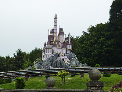 white and pink castle beside trees