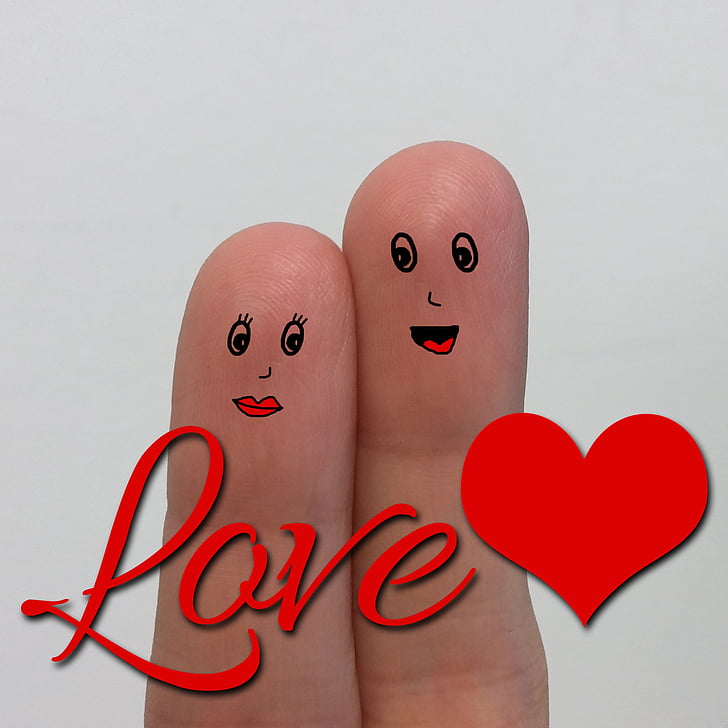 person's finger with love text overlay