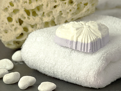 photo of white soap and white fabric towel