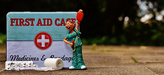 selective focus photography of First Aid Case with nurse figurine