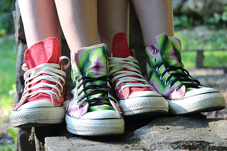 person wearing two pairs of red and green mid-rise shoes during daytime
