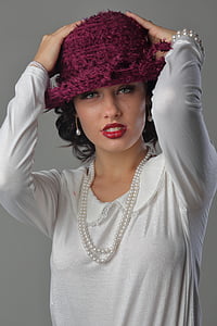 woman wearing pink knit cap touching her head