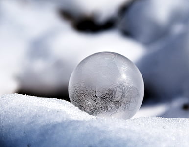 selective focus of glass ball at snowfield