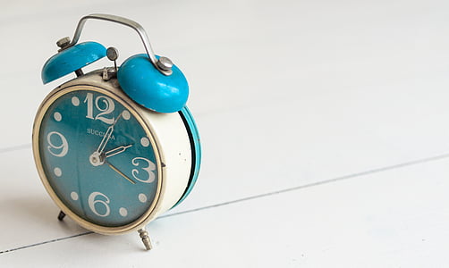 white and teal bell alarm clock