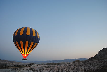 blue and yellow hot air balloon hovering above mountain