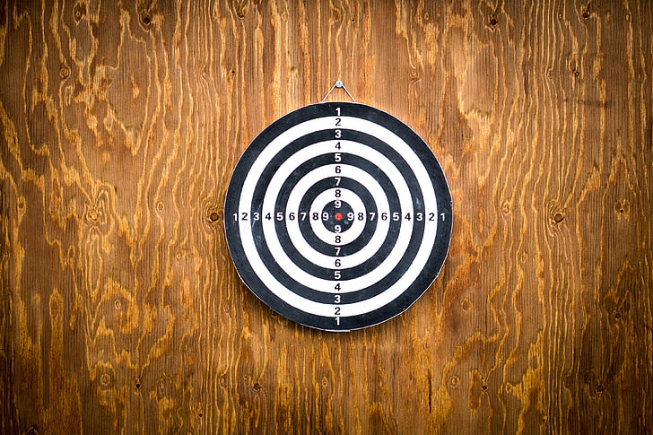 black and white dartboard hanged on wooden wall