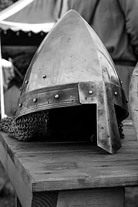 grayscale photo of knight helmet on table