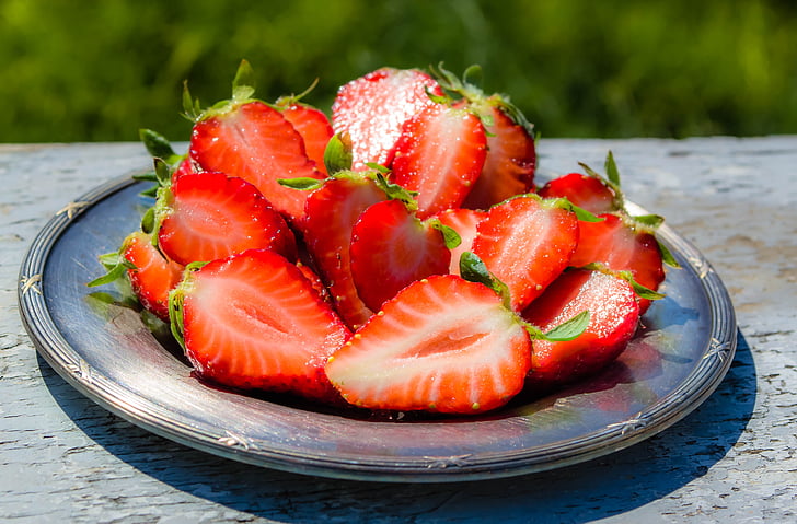 sliced strawberries on round gray plate