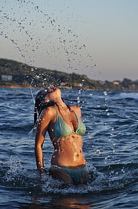 woman wearing blue bikini on body of water