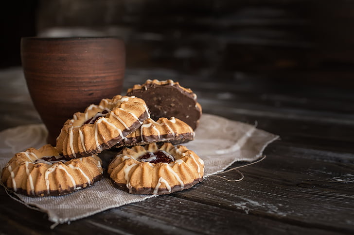 five cookies with brown wooden cup