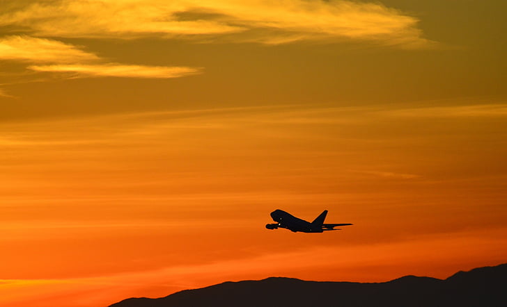 airplane taking off during sunset