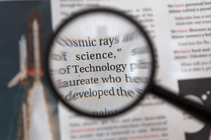 Technology word in magnifying glass