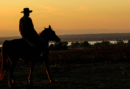 silhouette of man riding horse