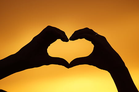 silhouette of two hands forming heart