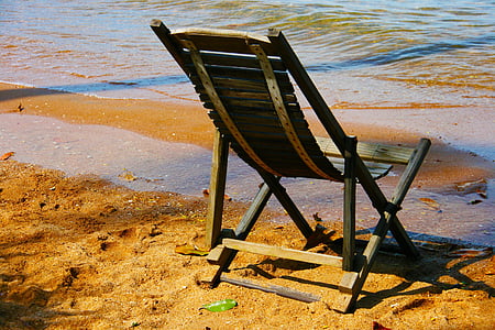 brown adirondack chair on seashore