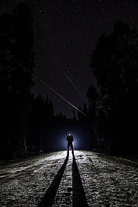 man wearing black hoodie under starry sky
