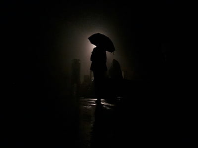 sihlouette photo of person holding umbrella