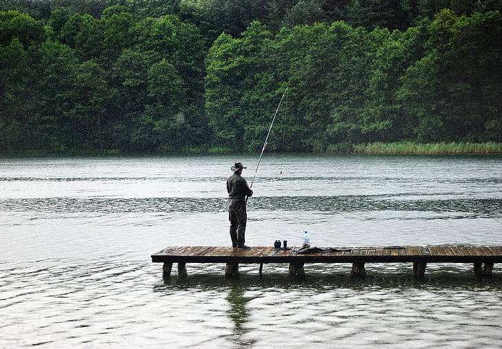 man fishing in the dock during daytime