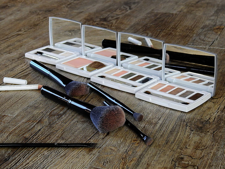 photo of four makeup palettes beside brush set