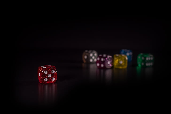 red die separated to multi-color dice in bokeh photography