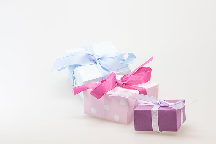 three pink, purple, and blue gift boxes on white background