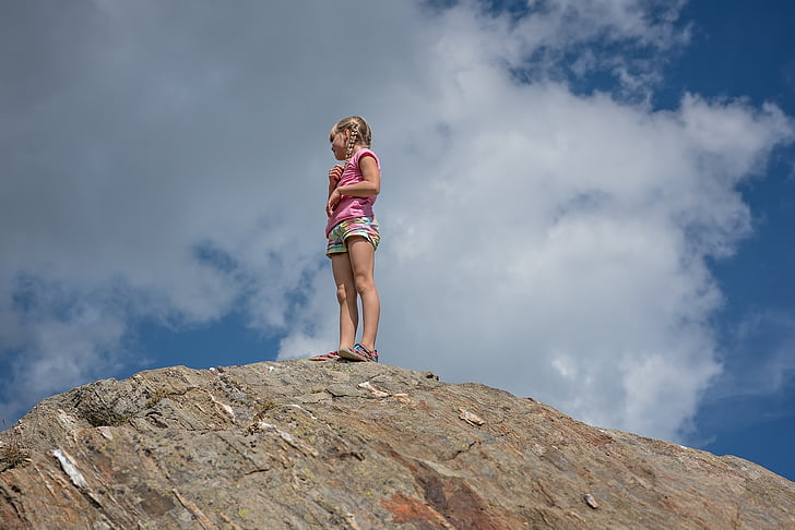 photo of girl standing on rock