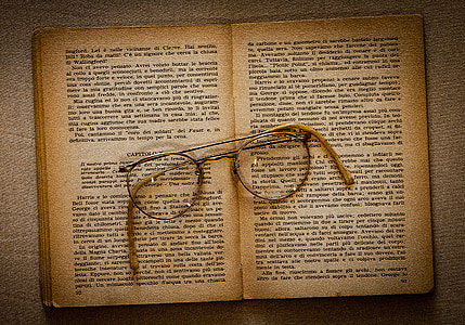 eyeglasses with silver frames on beige book pages