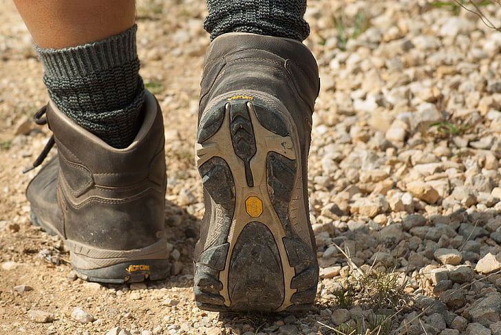 person wearing gray-and-white hiking boots