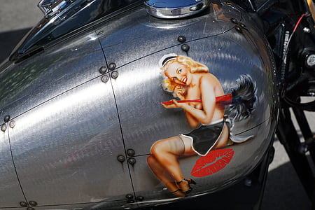 close up photography of gray motorcycle gasoline tank with woman sticker