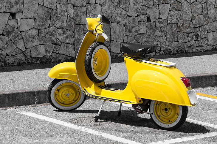 yellow motor scooter parked at side of street