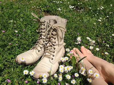 pair of white boots on plants with white flowers