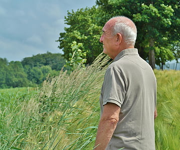 man wearing gray polo shirt surrounded by grass