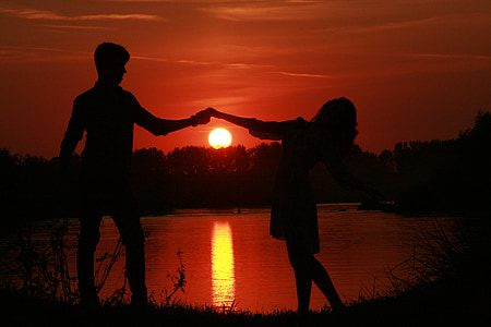 silhouette of man and woman dancing during sunset photo