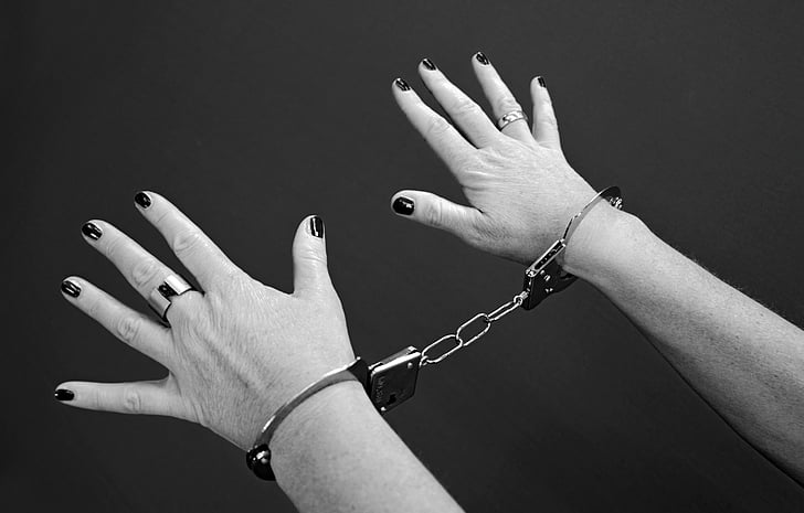 person showing hand with handcuffs