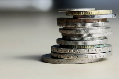 selective focus photography of stack of coins on white table