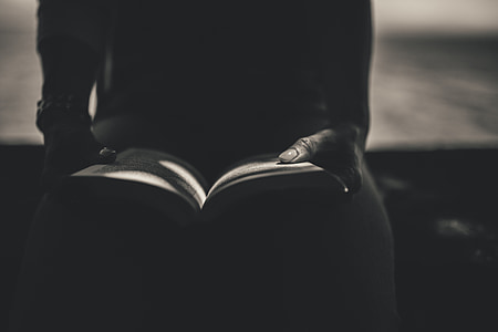 grayscale photography of person reading book
