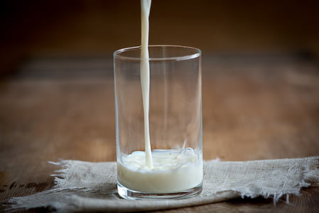 clear drinking glass pouring of milk