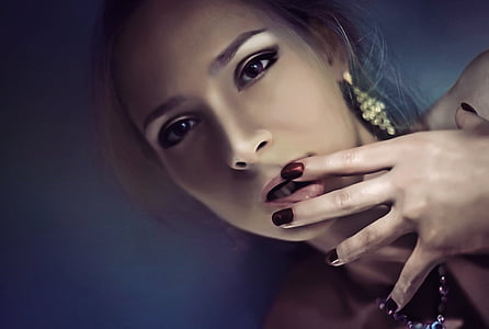 selective focus photography of woman with her hands on her lips