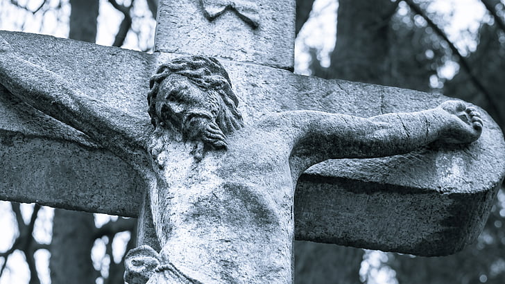 gray concrete crucifix near trees by day