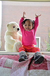 toddler sitting on table beside polar bear plush toy