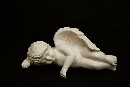 angel figurine against black background
