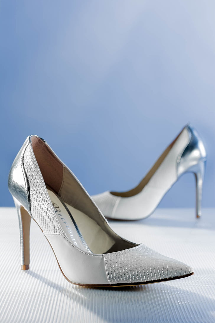 pair of silver leather pumps on white surface