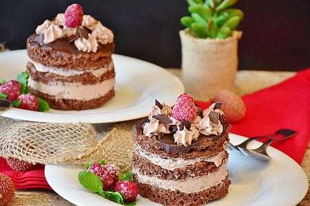 two raspberry on top mousse cakes on white ceramic plates