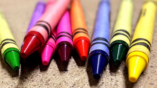 shallow focus photography of crayons on brown surface