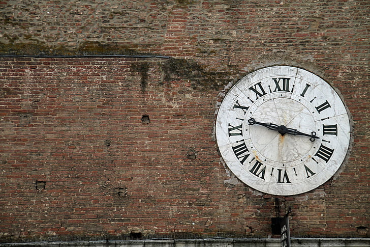 round white analog clock on wall at daytime
