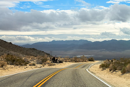 photo of gray asphalt road towards mountain range
