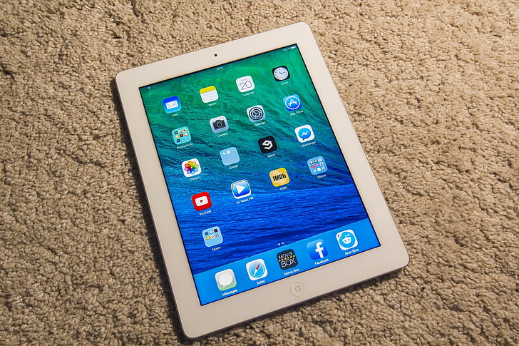 white iPad turned-on on beige textile